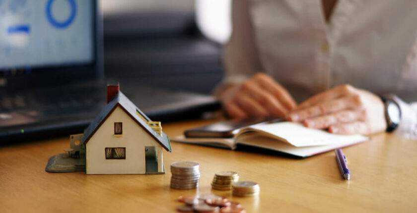 Small Home Model woith Coins on the Table