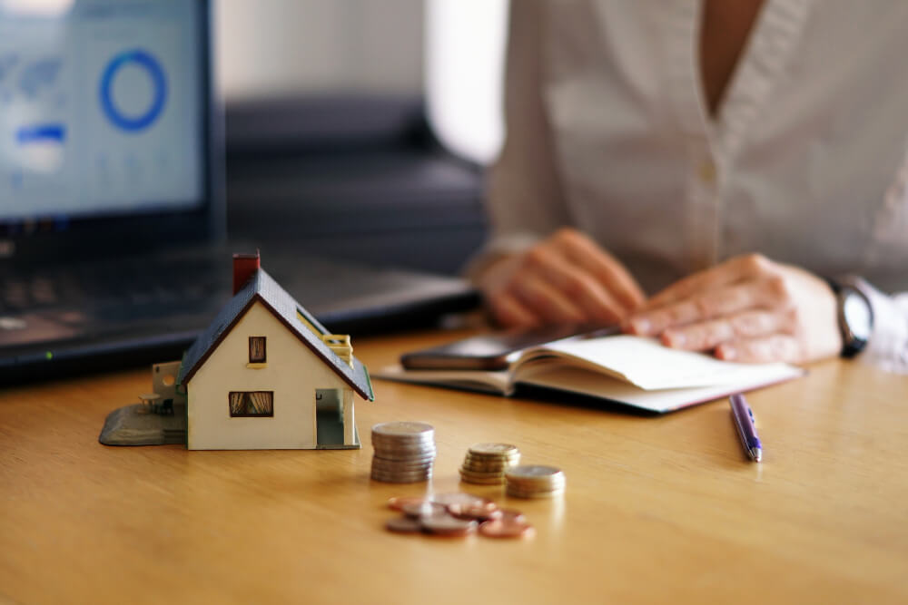 Small Home Model woith Coins on the Table