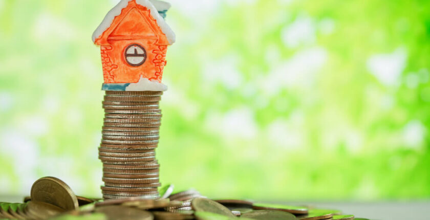 mini house stacked on coins