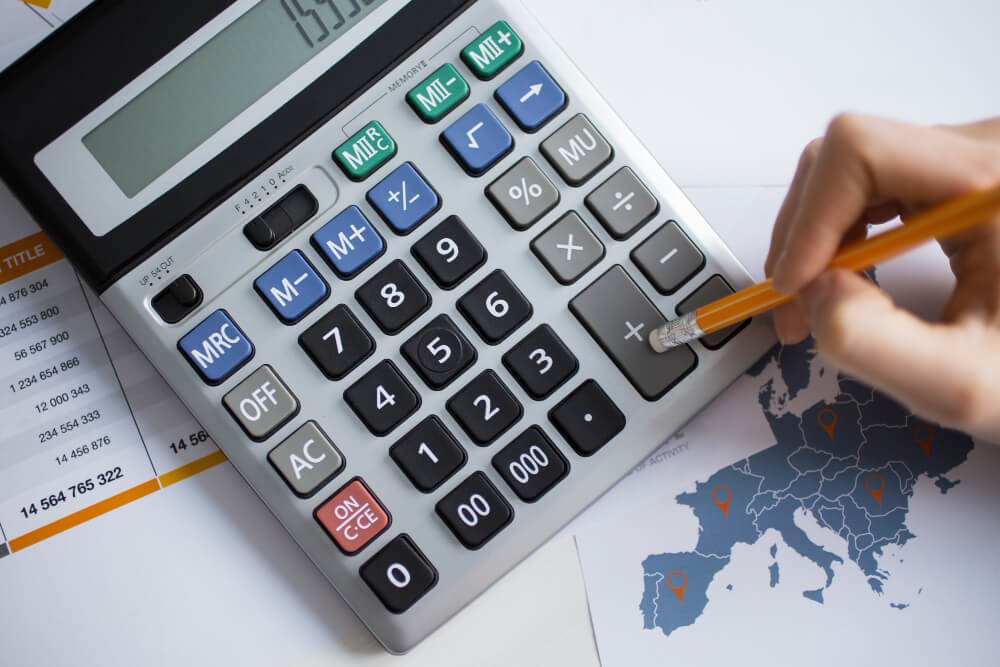 human using calculator with a pencil