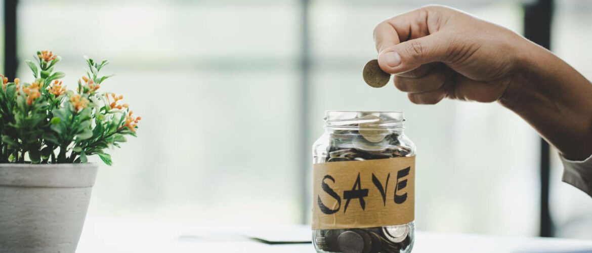 glass jar that says save and a person putting coins inside