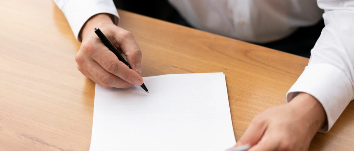 Man about to start a letter with blank page and a pen