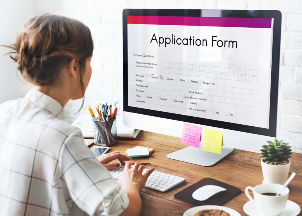 Woman sitting on a desk filling loan application form