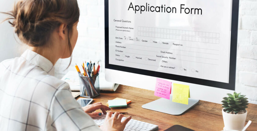 Woman sitting on a desk filling loan application form